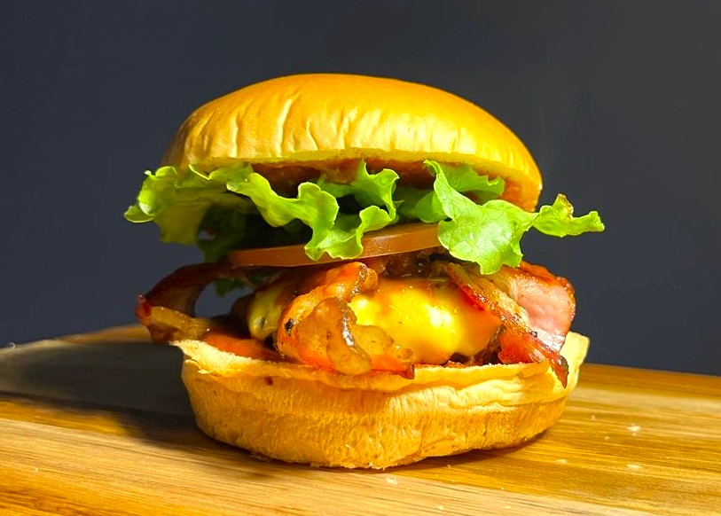 Hambúrguer duplo suculento com queijo derretido, bacon e cebola caramelizada